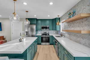 Kitchen featuring steel appliances and gorgeous backsplash.
