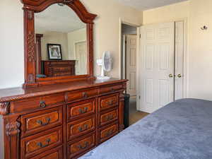 Bedroom with a textured ceiling and carpet floors