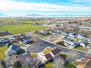 Aerial perspective of suburban area with mountains and extensive farmland