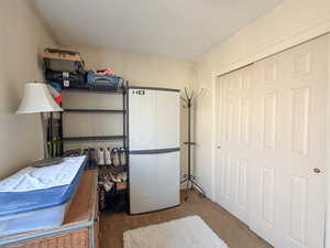 Bedroom with dark carpet, a textured ceiling, and a closet