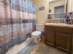 Full bathroom featuring a textured wall, vanity, and a shower with curtain