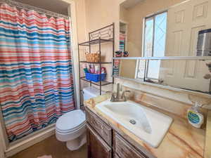 Full bath with a shower with shower curtain, wallpapered walls, and vanity