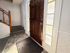 Foyer entrance featuring baseboards and stairway
