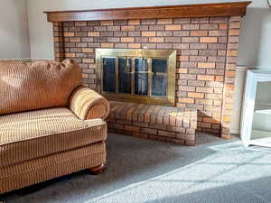 Detailed view of carpet and a brick fireplace