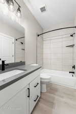 Bathroom with vanity, bathtub / shower combination, and light wood-style floors