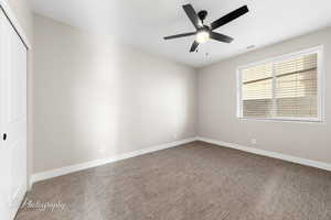 Unfurnished room with carpet and a ceiling fan
