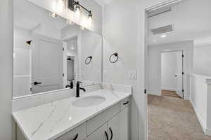 Bathroom featuring vanity, light colored carpet, recessed lighting, and a shower