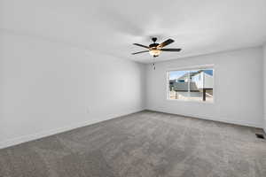 Empty room with light carpet and a ceiling fan