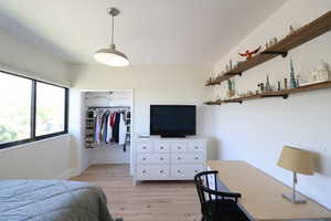 Bedroom featuring light wood floors and a spacious closet
