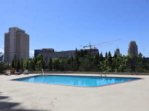 Community pool featuring a patio and a city view.