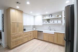 Kitchen featuring light brown cabinetry, Taj Mahal quartzite countertops.