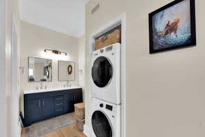 Bathroom featuring stacked washer and dryer, double vanity.