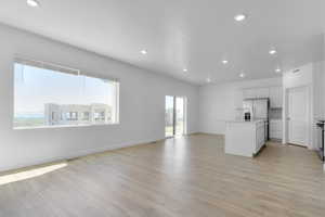 Unfurnished living room featuring light wood-type flooring and recessed lighting