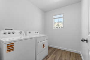 Washroom featuring light wood-style floors and washer and clothes dryer