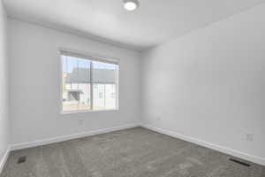 Carpeted empty room featuring baseboards