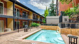 View of pool with a patio area and a balcony