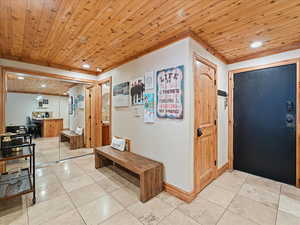 Entrance foyer with wooden ceiling, light tile patterned floors, and recessed lighting