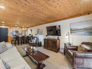 Living area featuring wood ceiling, light colored carpet, recessed lighting, and ornamental molding