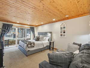 Bedroom featuring wooden ceiling, access to exterior, recessed lighting, carpet floors, and ornamental molding