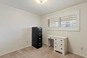 Office space with light colored carpet and baseboards