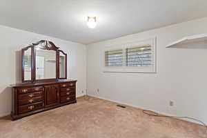 Bedroom featuring light carpet and baseboards