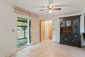 Unfurnished dining area featuring light tile patterned flooring and a ceiling fan