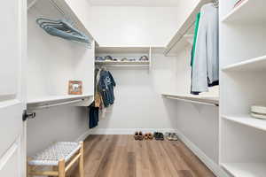 Walk in closet with light wood-style flooring
