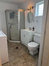 Full bath with washer / clothes dryer, vanity, and a stall shower