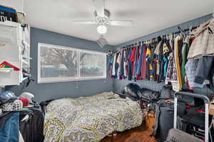 Bedroom featuring dark wood-style floors, a ceiling fan, a textured ceiling, and a closet