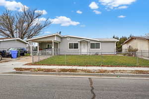 View of front of home with an attached carport, driveway, and a fenced front yard