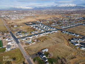Aerial view of property and surrounding area featuring nearby suburban area and a mountainous background