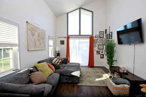 Living area with high vaulted ceiling and wood finished floors