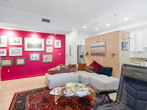 Living room featuring rail lighting, wood finished floors, and recessed lighting
