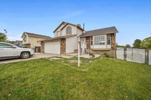 View of front facade with concrete driveway, a gate, a patio area, and stone siding