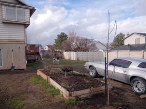 View of yard with a garden, a fire pit, a deck, a residential view, and stairway