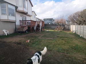Fenced backyard with stairway, a deck, and a residential view