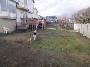 Fenced backyard with stairway, a deck, and a residential view