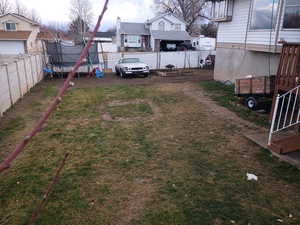 Fenced backyard with a trampoline and a residential view
