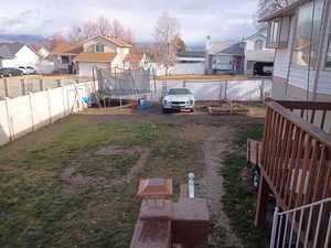 Fenced backyard featuring a trampoline and a residential view