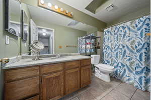 Bathroom with vanity, a shower with shower curtain, light tile patterned floors, and a textured ceiling