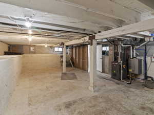 Basement featuring heating unit and water heater
