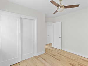 Unfurnished bedroom featuring a closet, ceiling fan, and light wood-type flooring