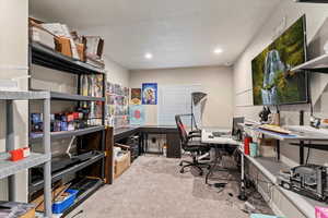 Office with light carpet and recessed lighting