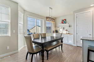 Dining space featuring light wood-style flooring and a chandelier