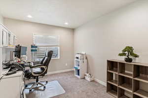 Home office with light carpet and recessed lighting
