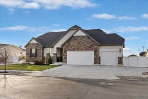 Craftsman-style house featuring a gate, driveway, a garage, stone siding, and roof with shingles
