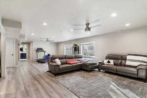 Living room featuring recessed lighting, ceiling fan, and light wood-style floors