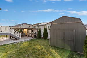 View of green lawn featuring a patio, stairway, and a shed
