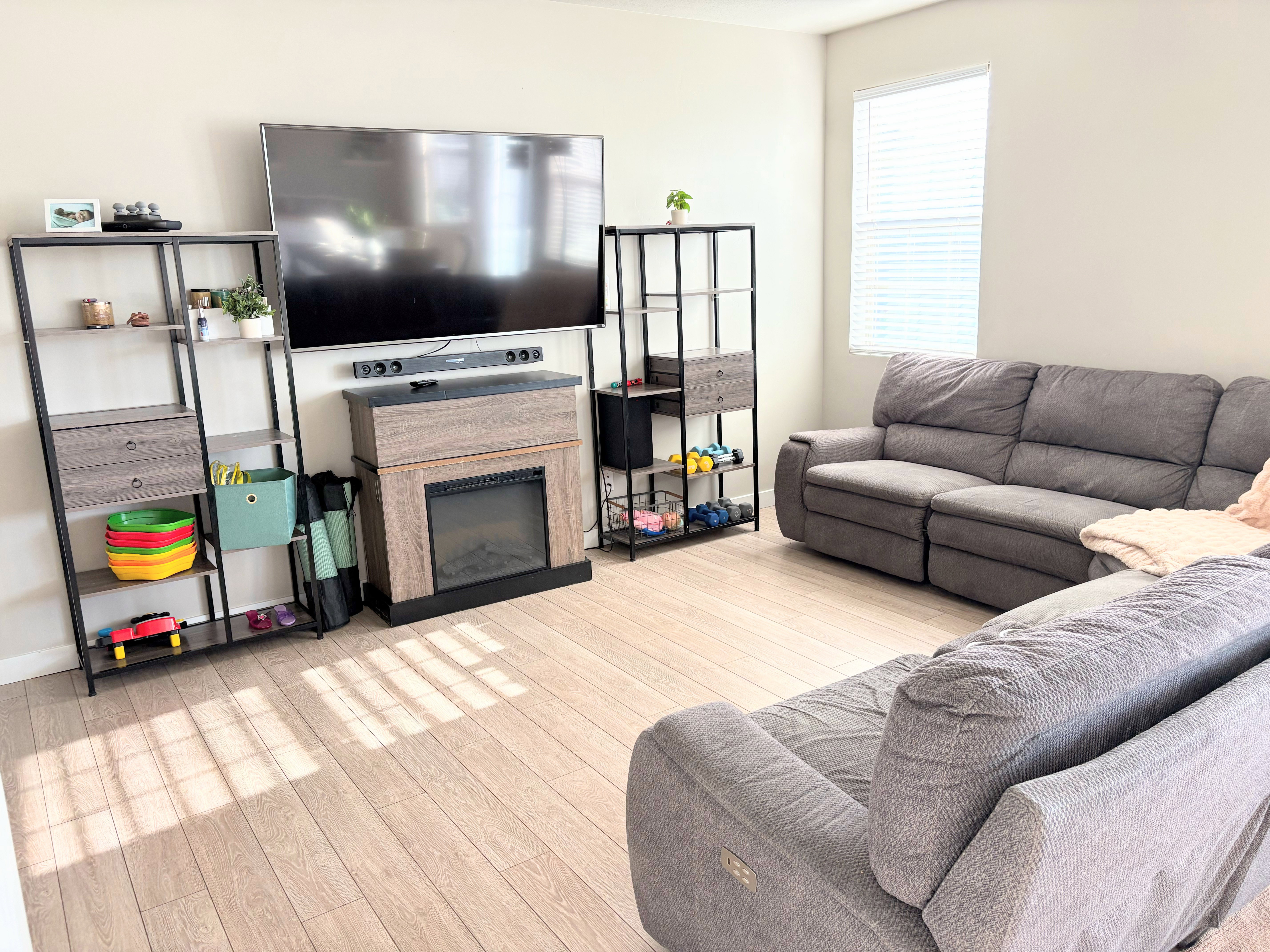 Living room with light wood-style floors and a glass covered fireplace