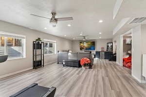 Playroom with light wood-type flooring, a ceiling fan, wine cooler, and recessed lighting